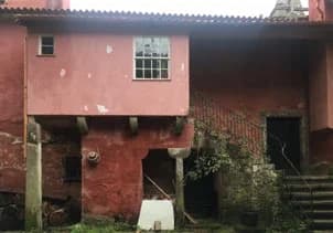 A derelict wing of the red house on its stone piers, its windows long gone