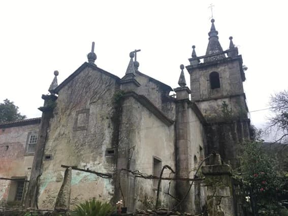 The church before restoration, its walls patched and overgrown with vines