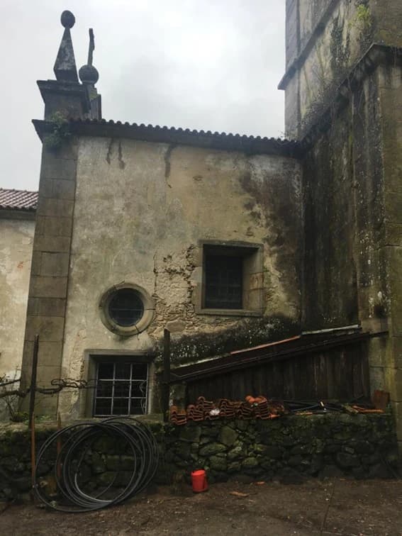 A derelict wing of the monastery, roof tiles stacked against the wall awaiting the restoration