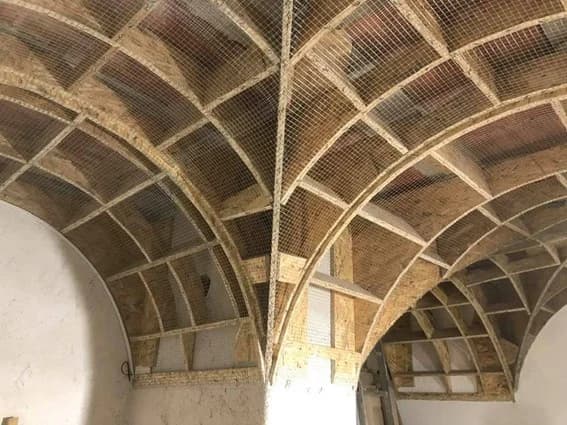 The groin vault mid-restoration, its timber frame and safety netting still in place