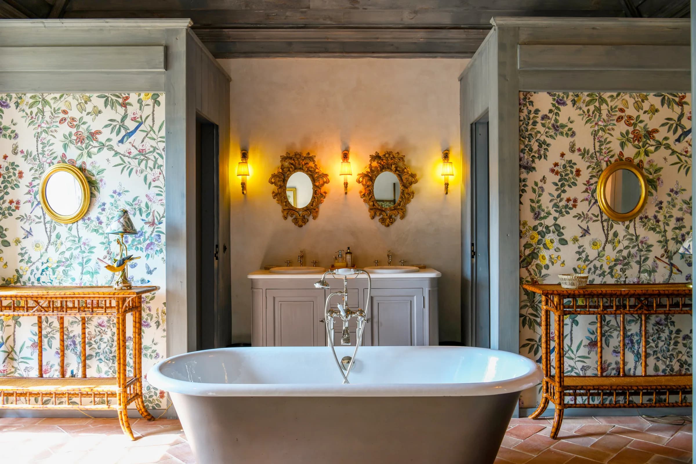 The Camelia bathroom — a freestanding tub beneath bird-and-flower wallpaper