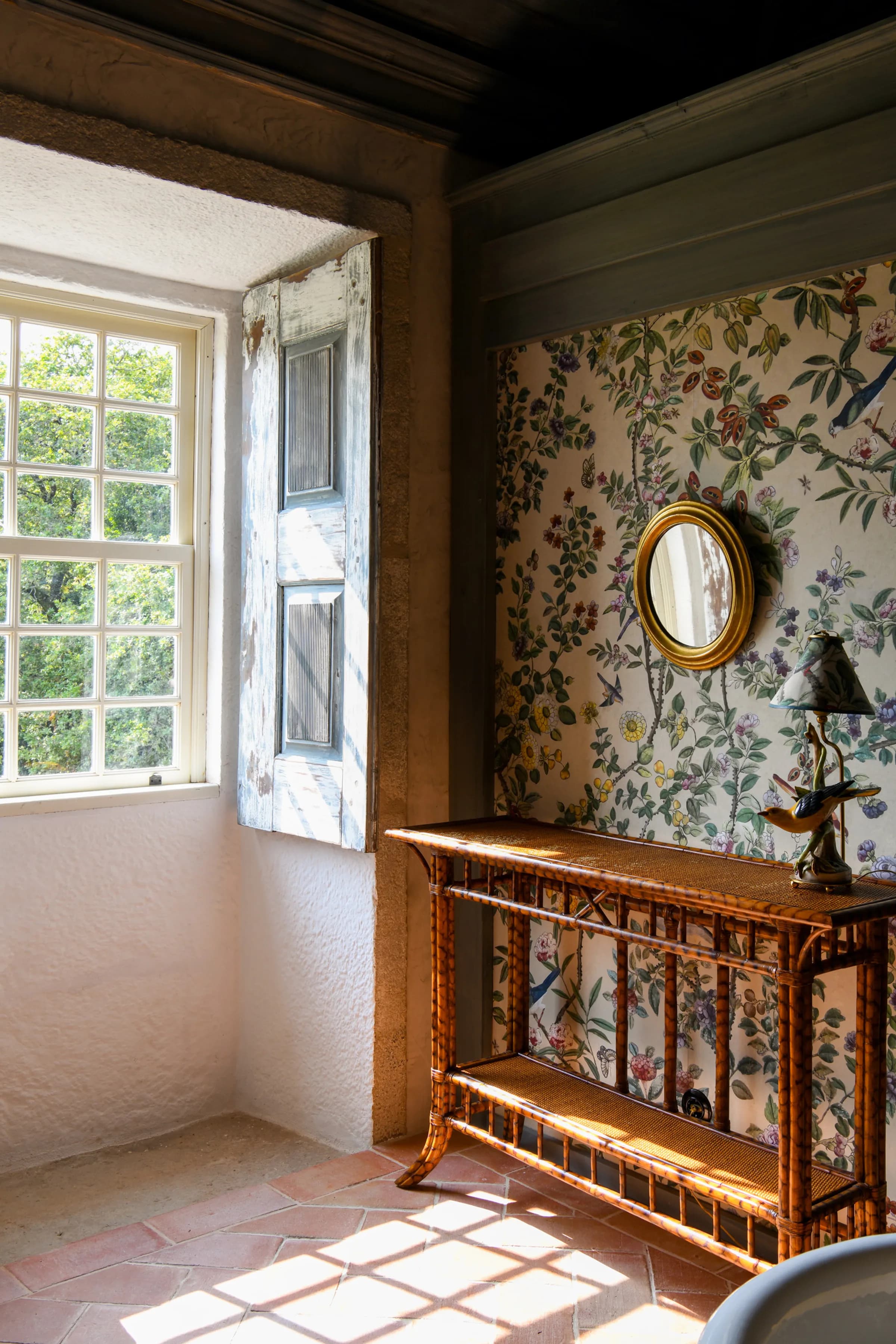 The Camelia suite — the bed dressed in a red-and-green floral quilt by the window