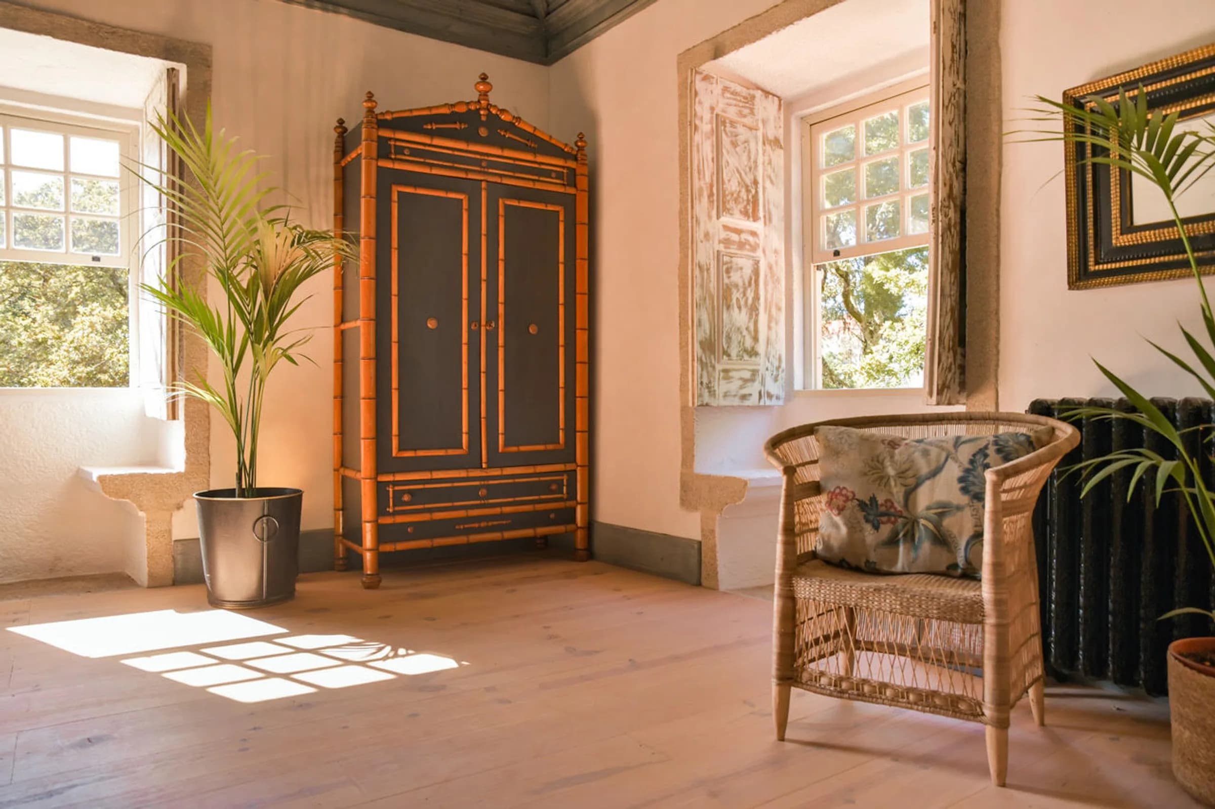 The Dahlia suite — rattan armchairs beside the open window