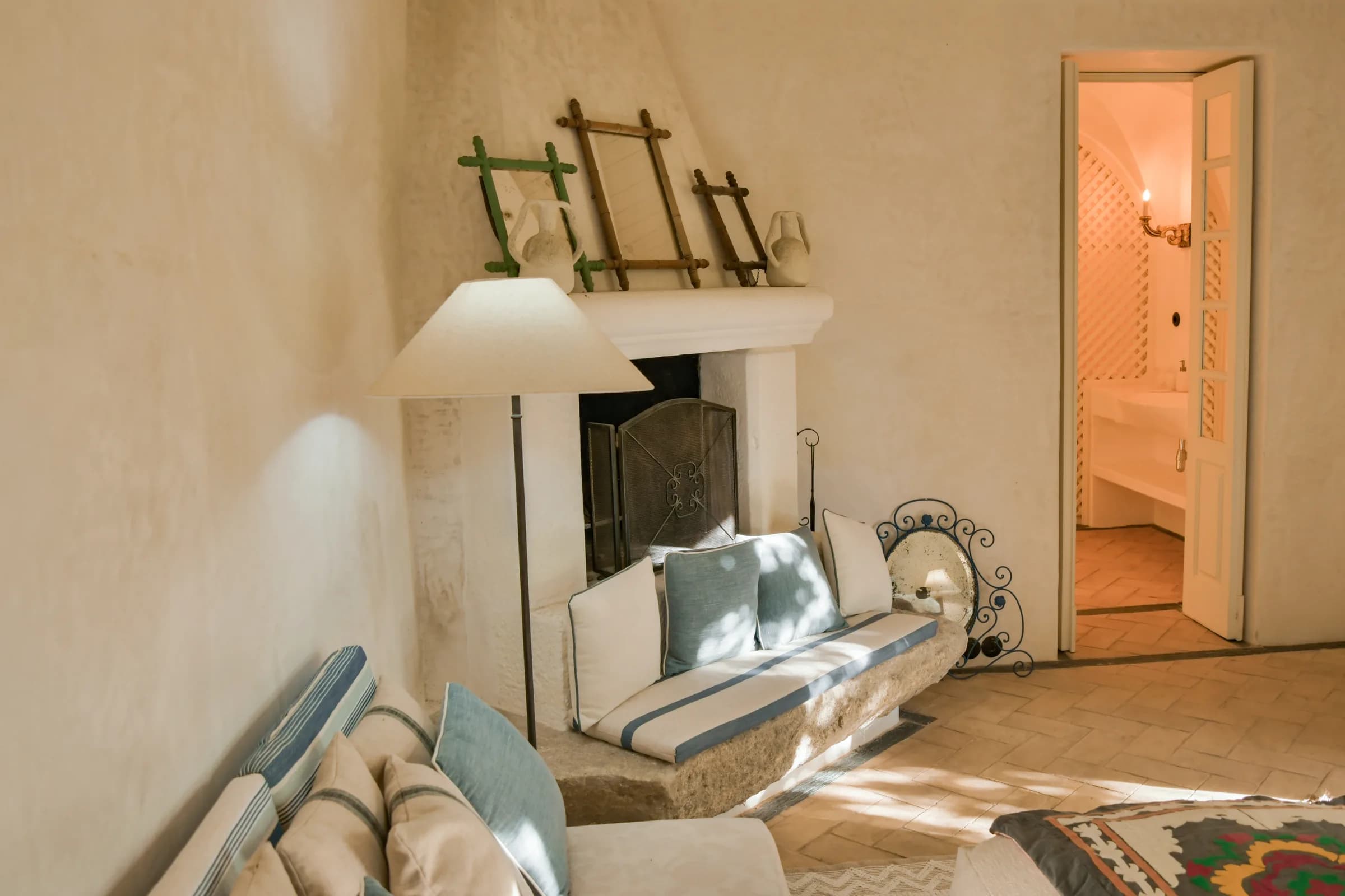 The Hortensia cottage — the fireside stone bench, antique frames on the mantel