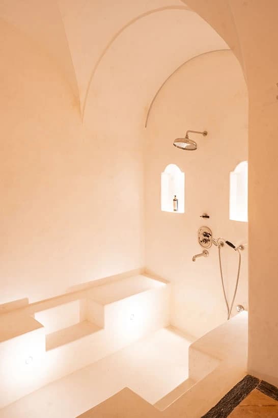 The Hortensia bathroom — vaulted ceilings and a glowing sunken tub