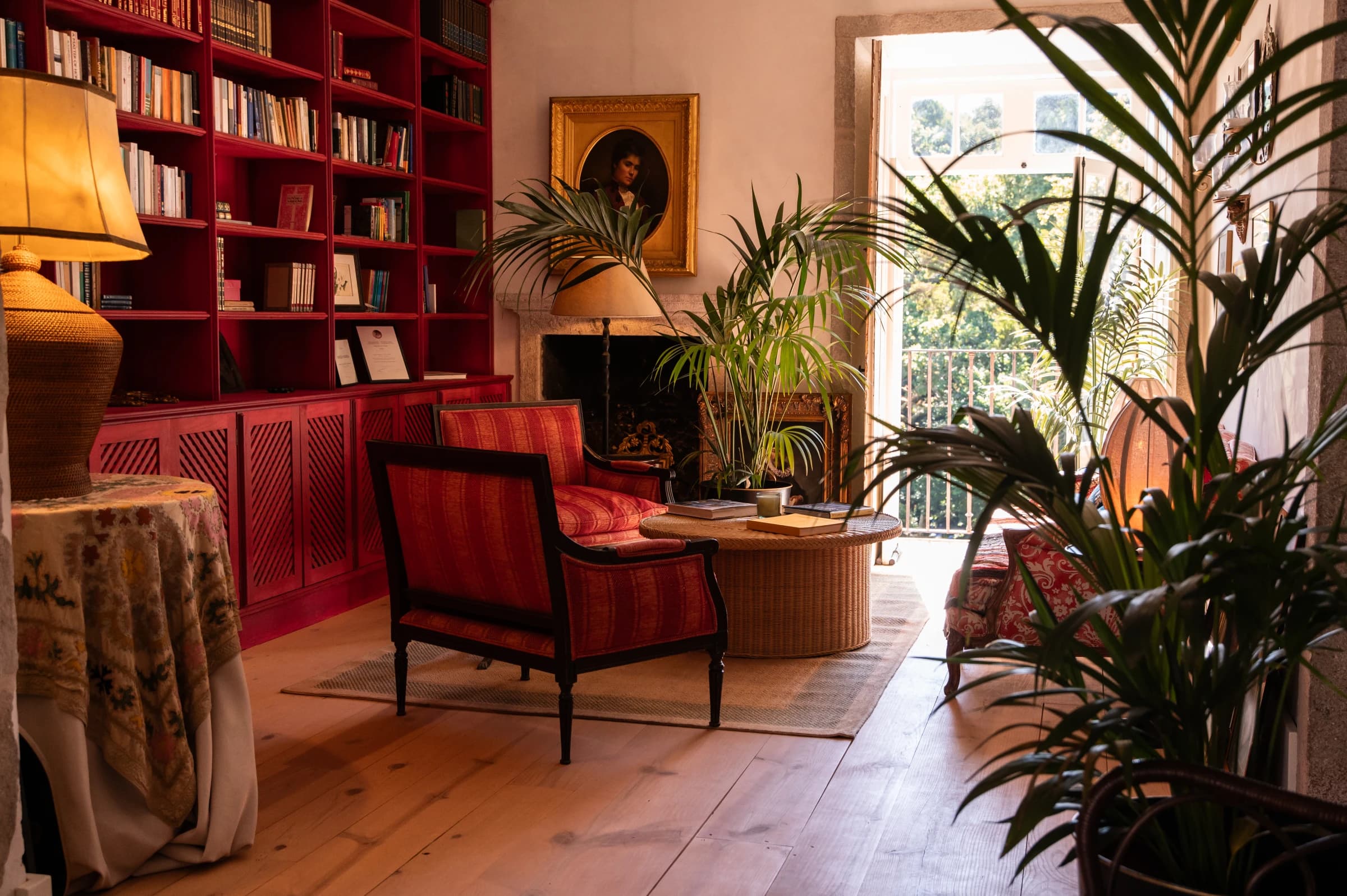 The library's red bookshelves and fireplace, an antique portrait above the mantel