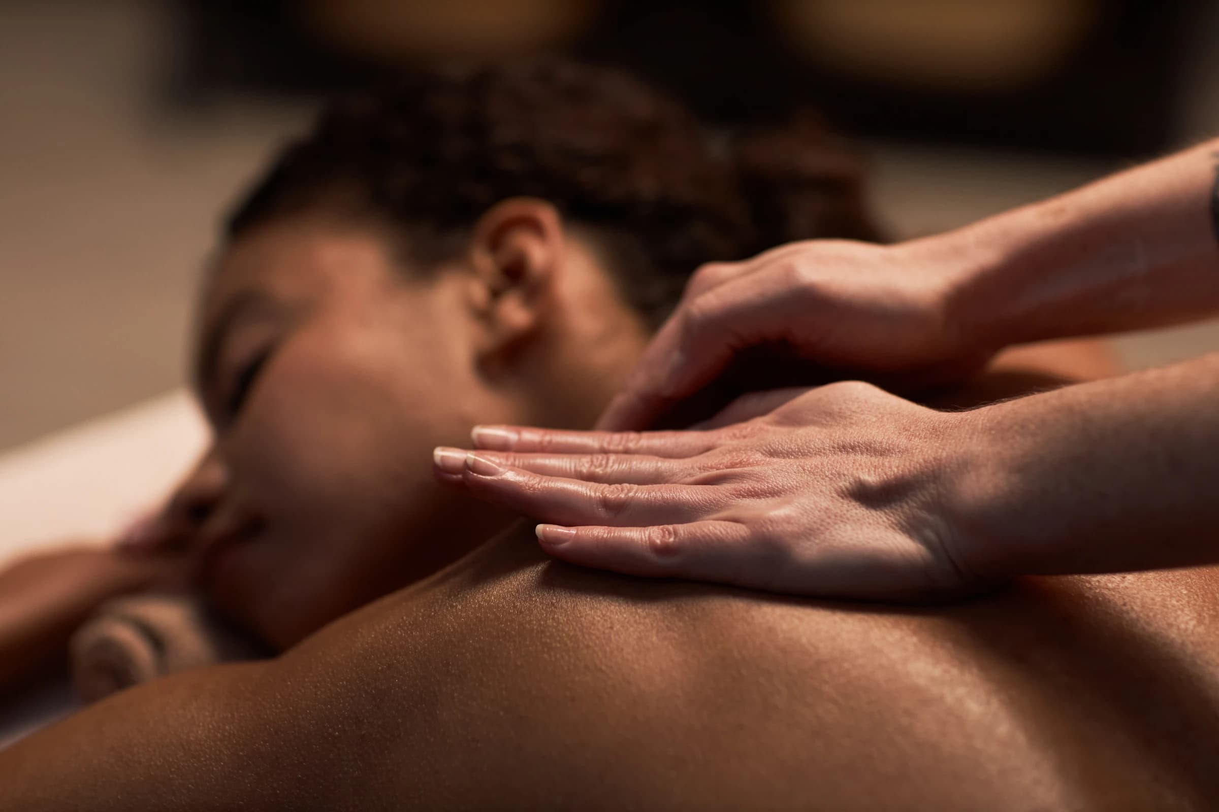 A guest receiving a back massage by warm candlelight