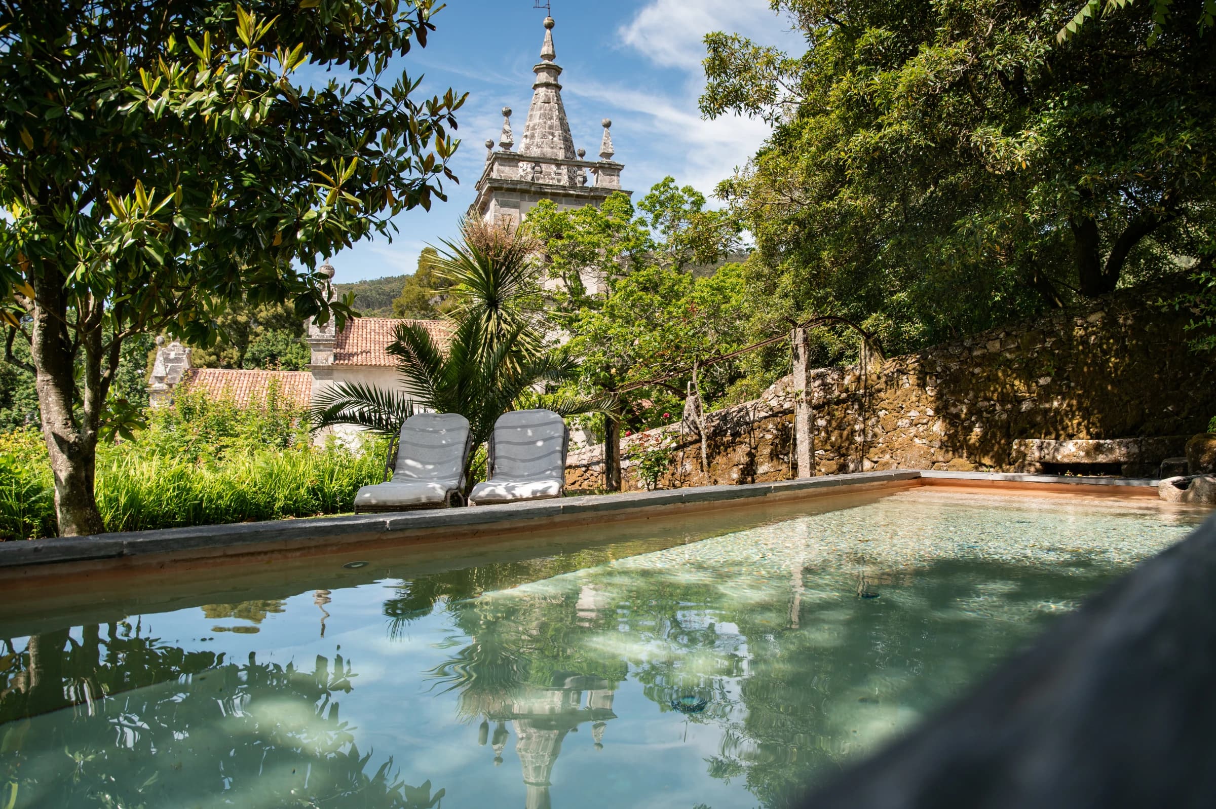 The Convento's swimming pool beneath the church tower and old trees