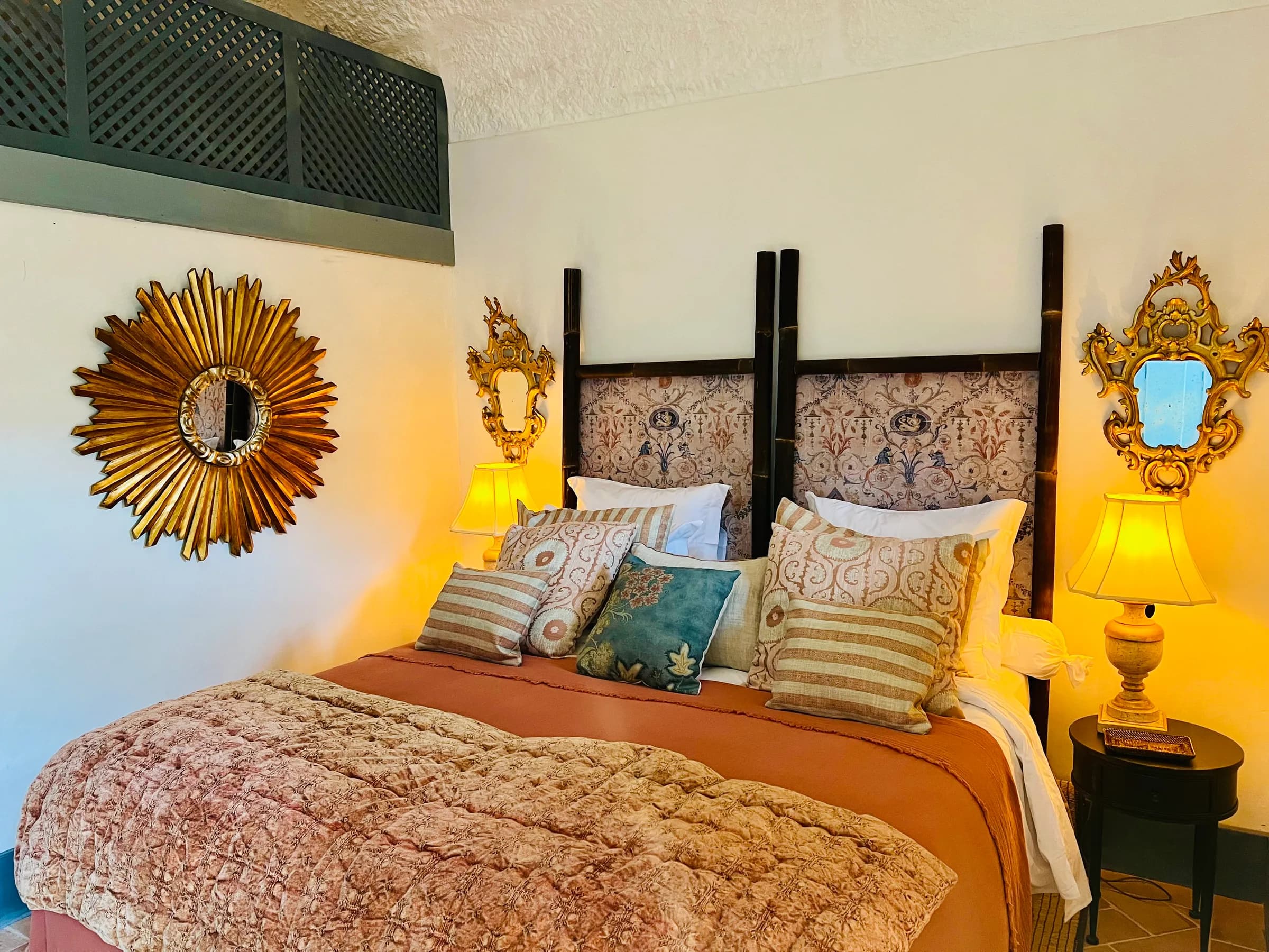 La suite Azalée — un miroir soleil doré au-dessus du lit