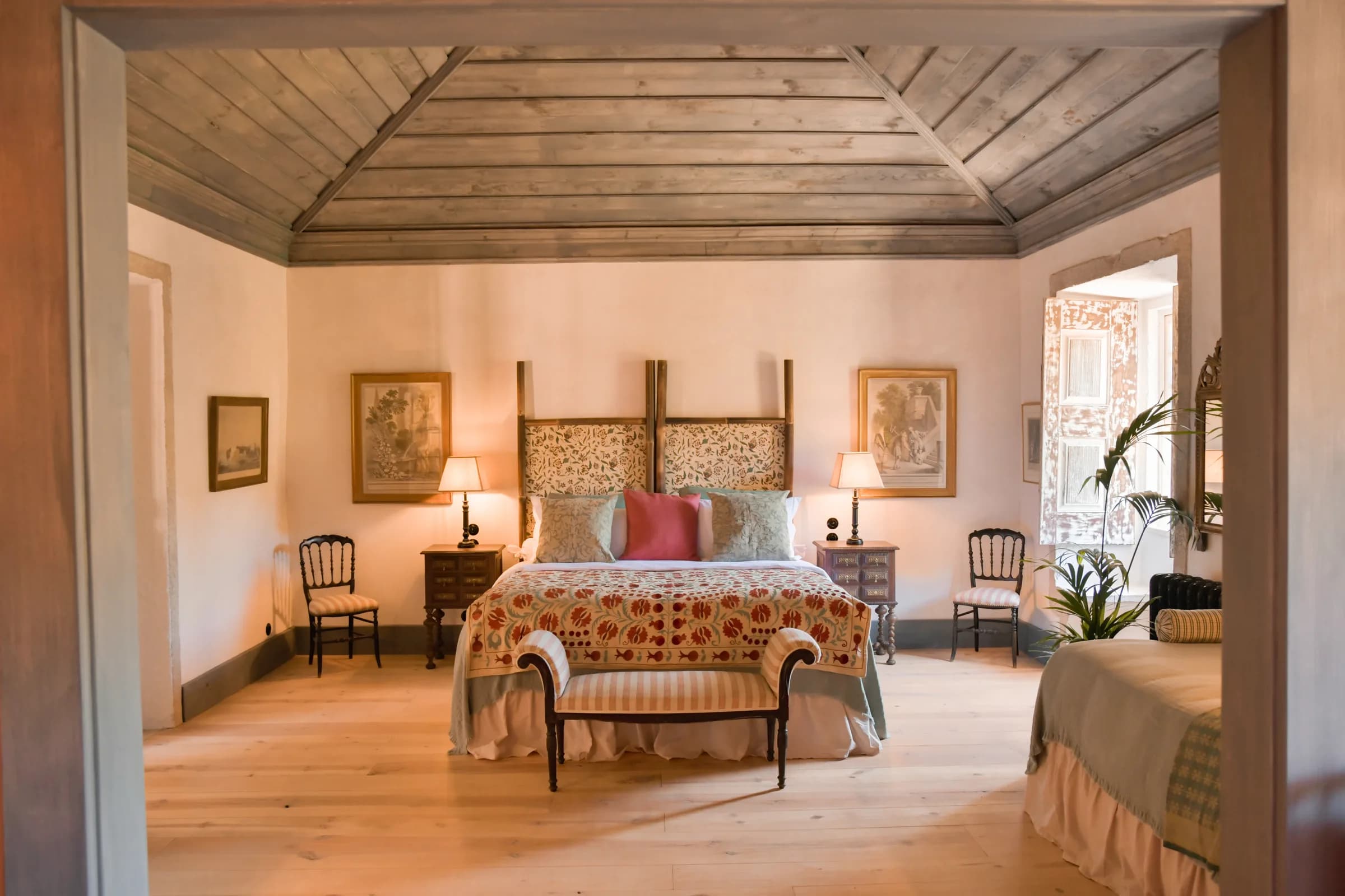 La suite Camelia — le lit sous le plafond en bois peint