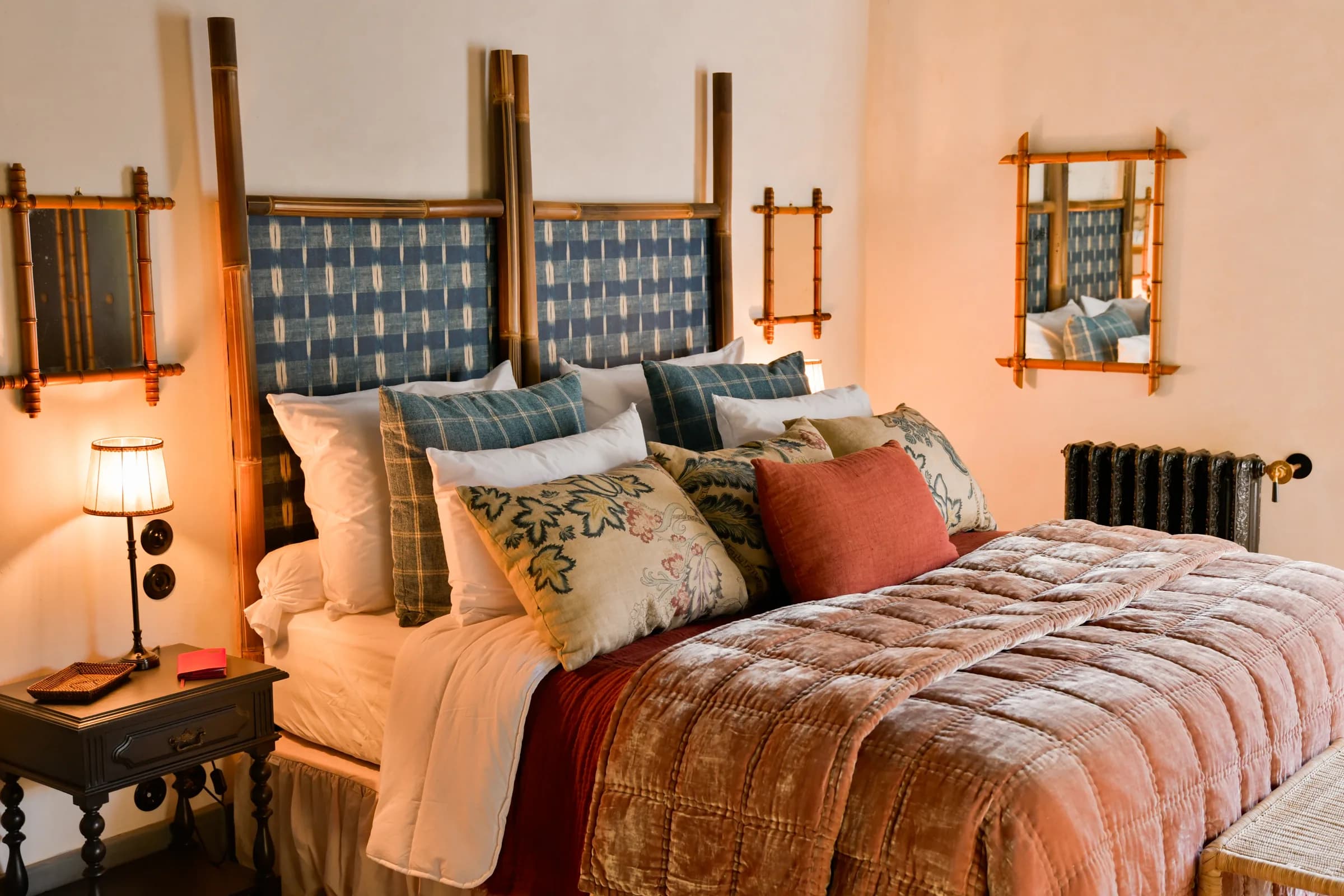 La suite Dahlia — le lit à baldaquin en bambou habillé de corail et d'indigo
