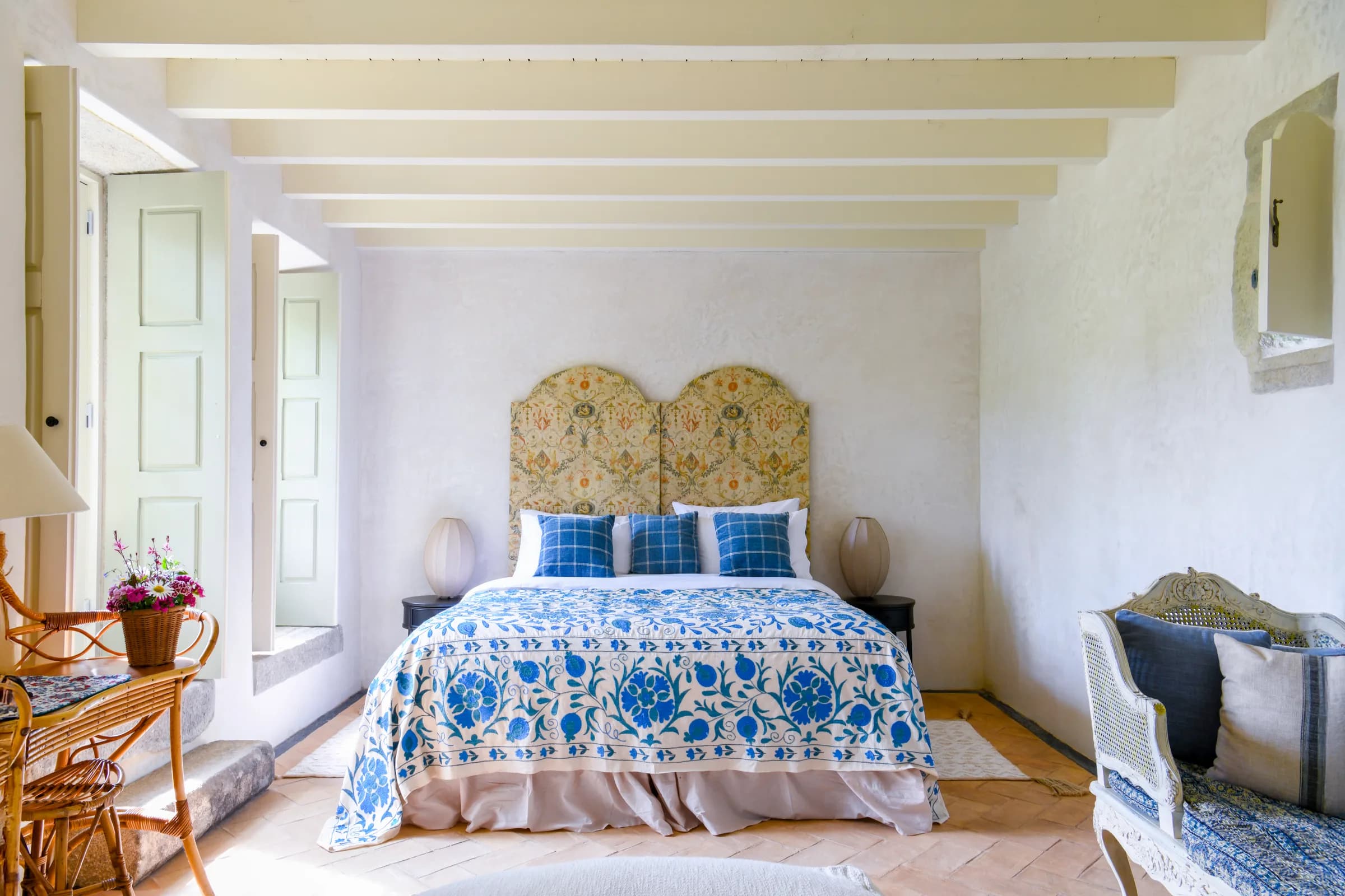 La suite Hortensia — un dessus-de-lit suzani bleu et blanc sous une tête de lit fleurie