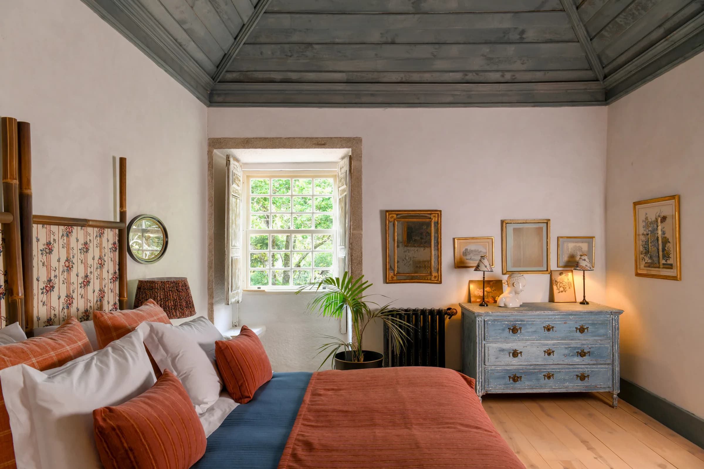 La suite Lilas — le lit sous le plafond en bois, commode bleue au fond